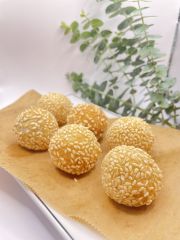 Sesame Balls features glutinous rice balls filled with red bean paste, coated in white sesame seeds, and deep - fried to a golden brown at JCK Asia Kitchen & Bar, a Asian Cuisine restaurant in Chula Vista