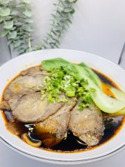 JCK-Asia-Kitchen-&-Bar-Asian-Cuisine-restaurant-Braised-Pork-Noodles-Chula Vista Braised Pork Noodles features tender braised pork slices served on noodles in a savory broth, topped with scallions and bok choy at JCK Asia Kitchen & Bar, a Asian Cuisine restaurant in Chula Vista